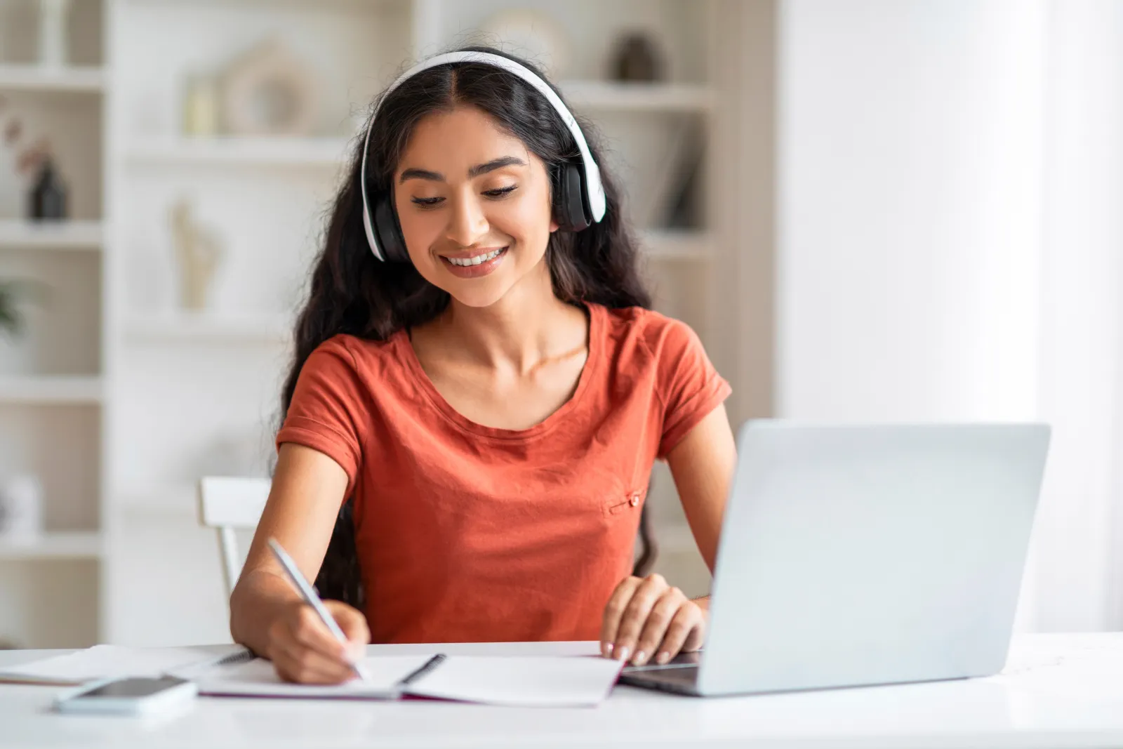 Student writing notes in an Enhance English IELTS class